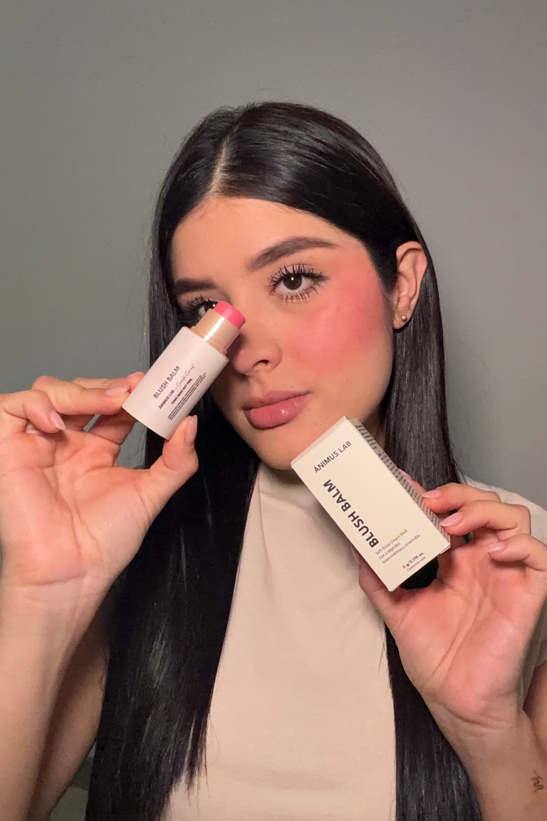 Blush Balm — modelo sosteniendo el rubor en barra